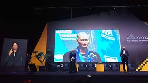 Auf der Bühne des OGP Summit wurde ein Roboter aufgebaut, der mittels KI in der Lage war, die Gäste eigenstädndig zu begrüßen